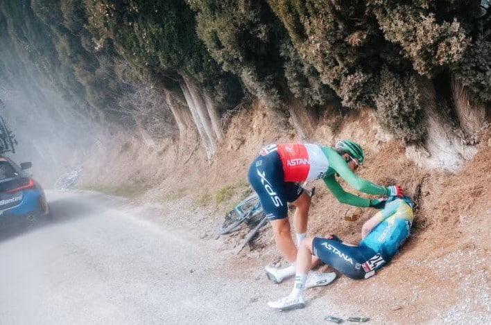 Alberto Bettiol (XDS Astana) asistiendo a Christian Scaroni en Strade Bianche 2025.