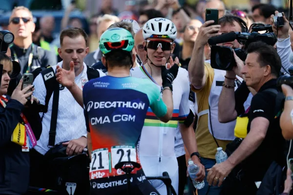 Paul Seixas (Decathlon CMA CGM) tendiendole la mano a Tadej Pogacar (UAE Team Emirates) tras su segundo lugar en Lieja-Bastoña-Lieja 2026